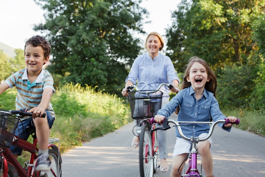 A person and a young person riding bikes down a street.