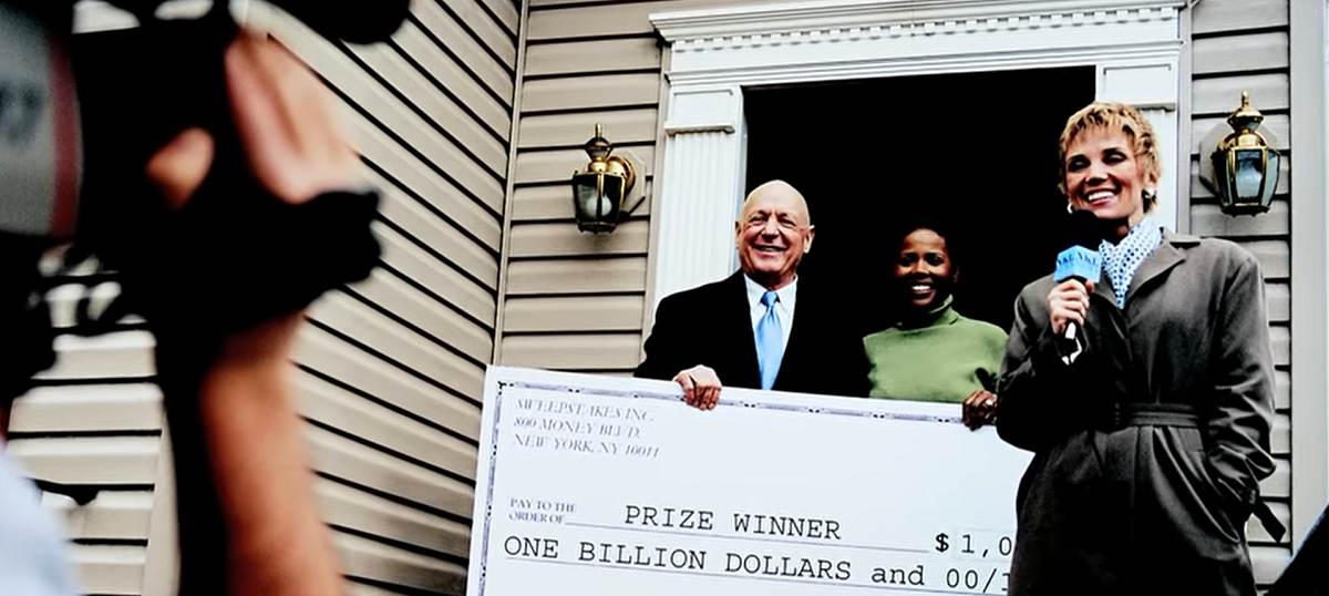 prize winner receives oversized check in front of home