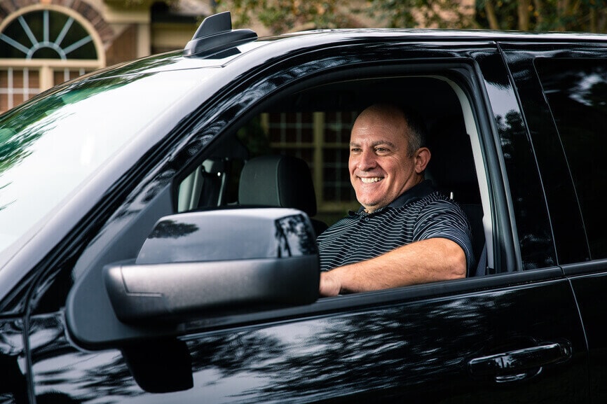 Smiling man driving his new truck.