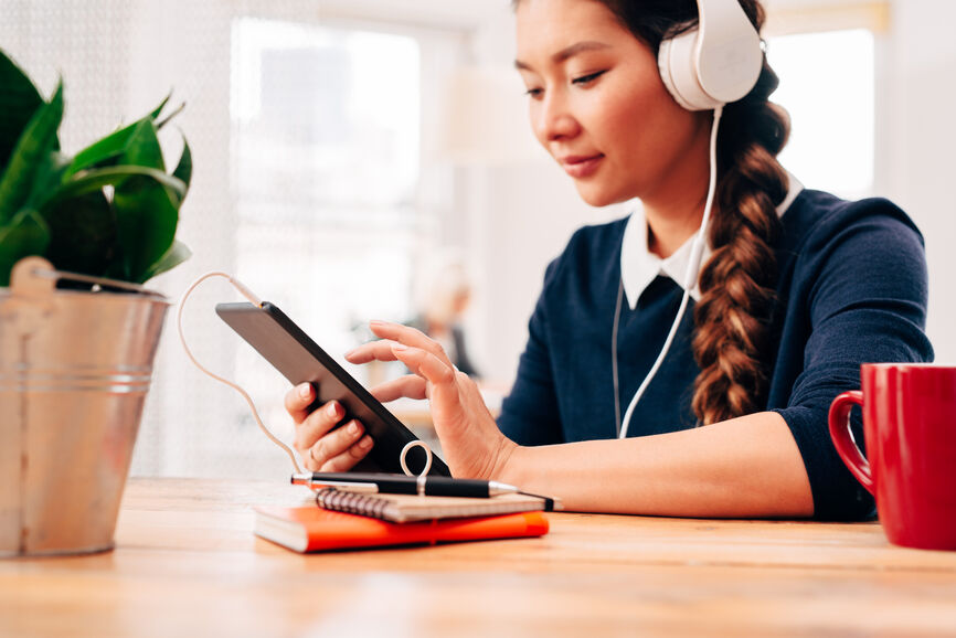 woman wearing headphones and working on her tablet