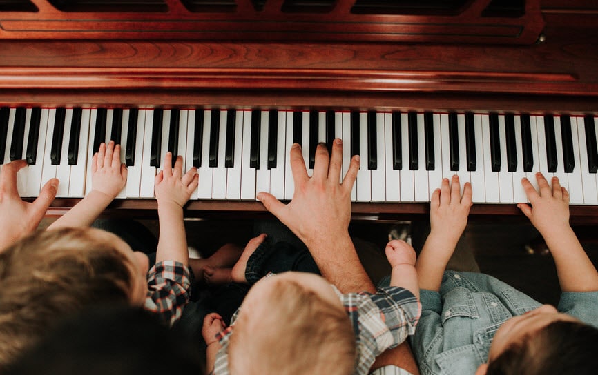 Father and sons playing piano