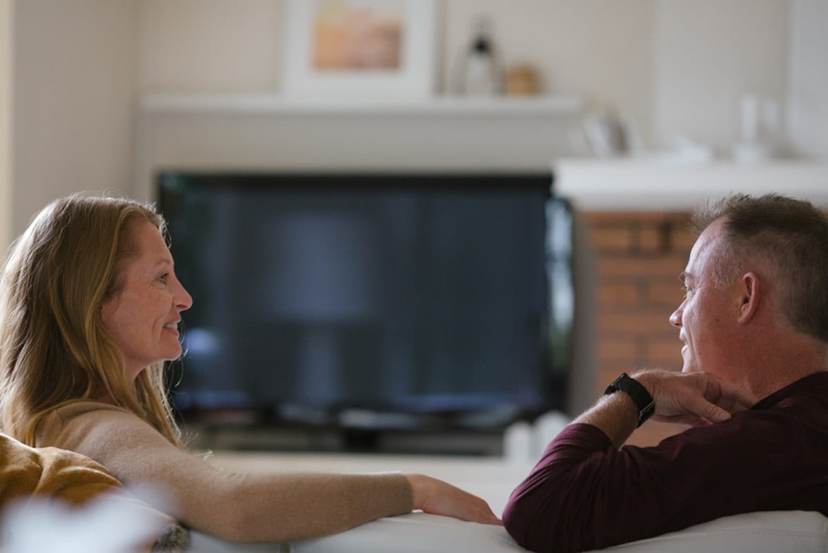 Two people chatting on a couch