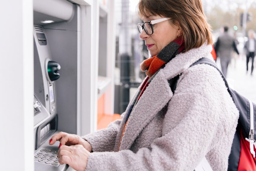 Woman using an ATM to withdraw her tax refund.