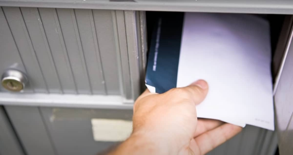 hand taking mail out of box