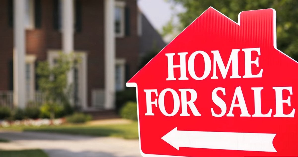 home for sale sign in front of large house