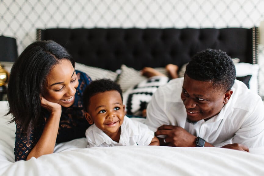 A mother and father admiring their happy baby.