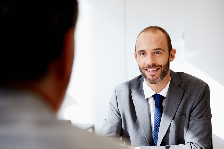 A professional man in a suit confers with a client.