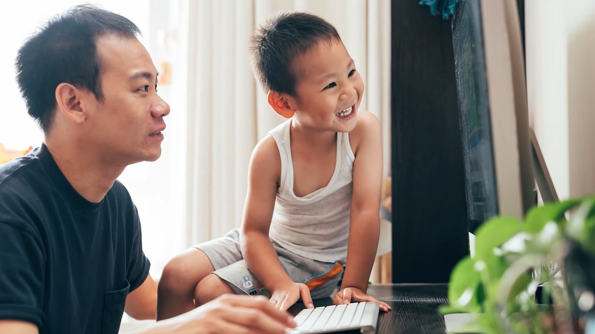father and happy little boy looking at a computer monitor