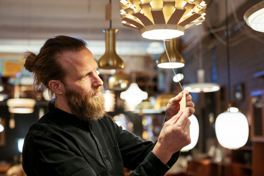 Man looking at price tag on lamp.