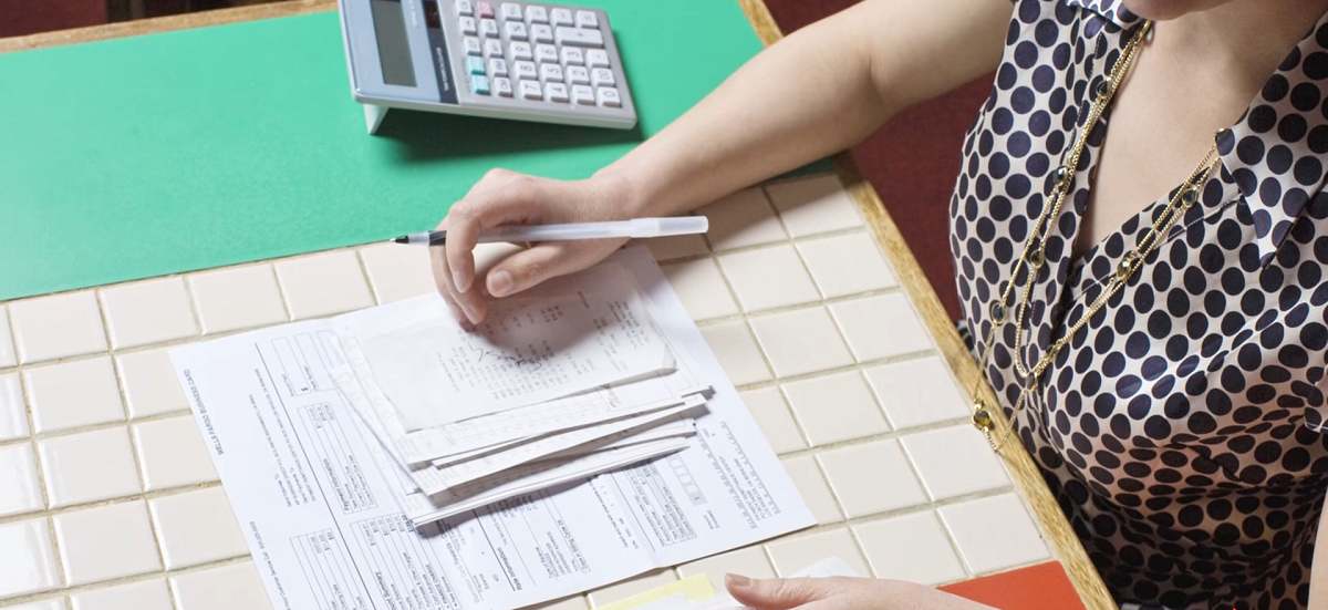 woman holding pen and reviewing receipts