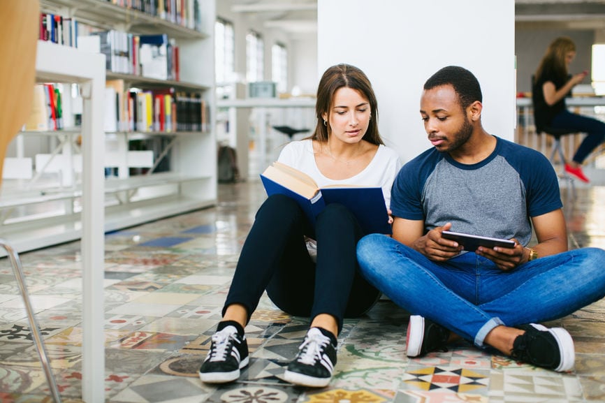 University Friends Studying Together In A Library.