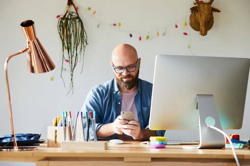 man with a beard sitting at his computer