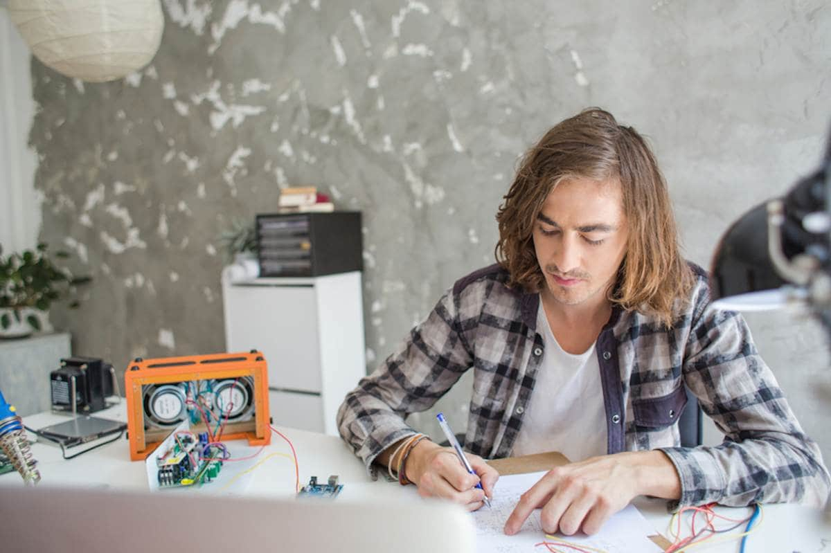 Male engineering student works on a project at home