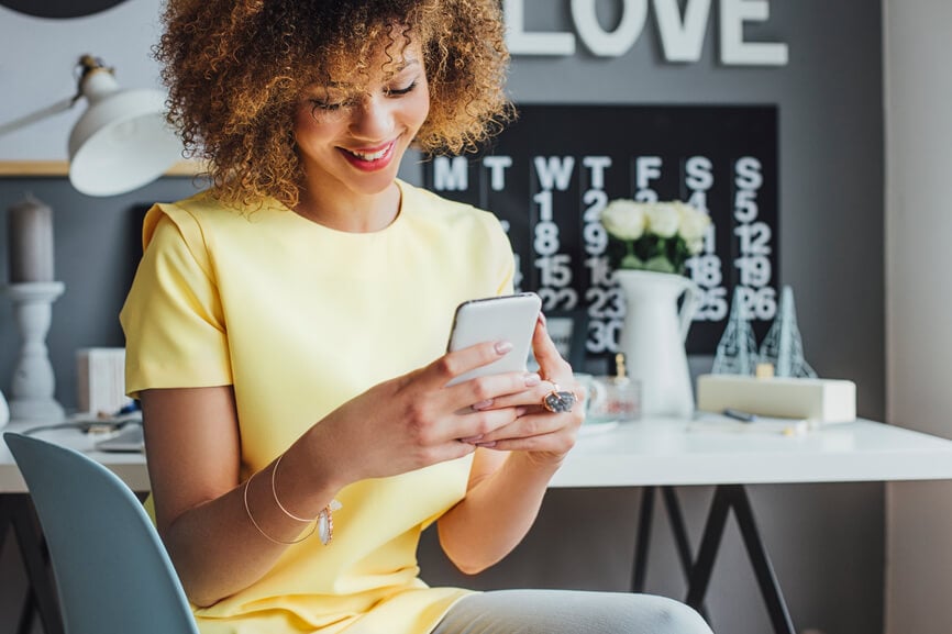 smiling woman reading on her phone and making calendar plans