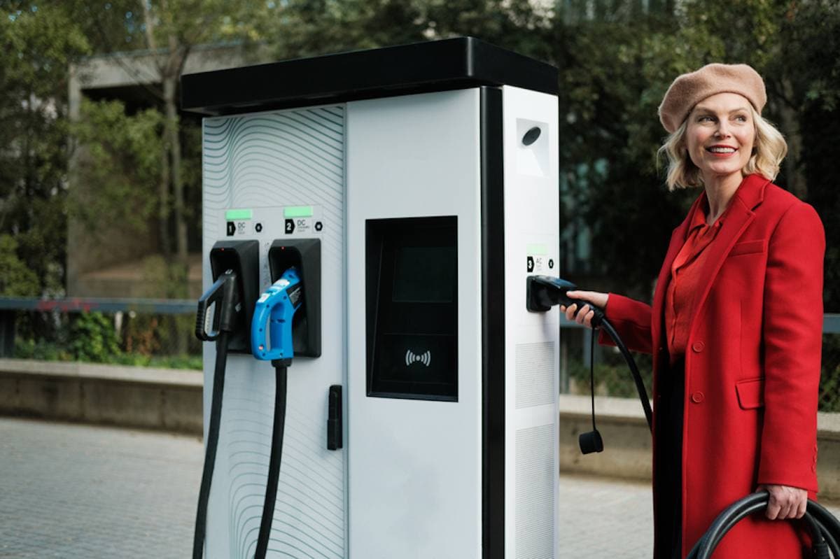 Woman standing at EV charging station