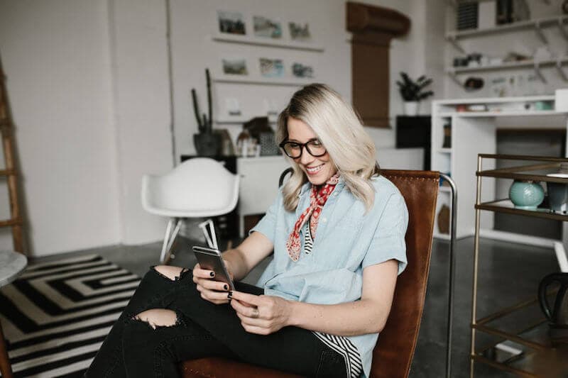 Person seated on couch looking at phone