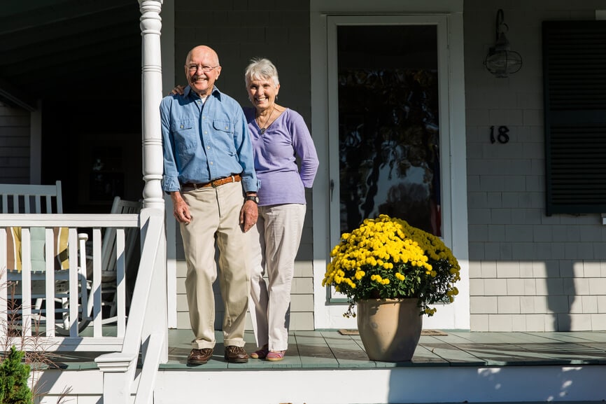 Senior couple enjoying the sunshine on their front porch.