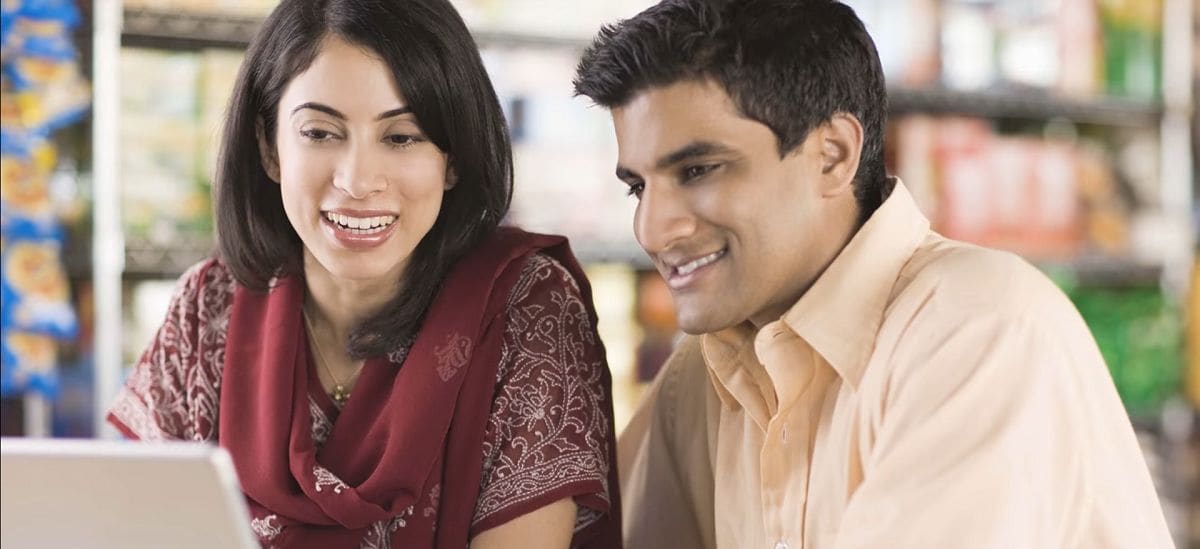 smiling couple looking at a laptop computer screen