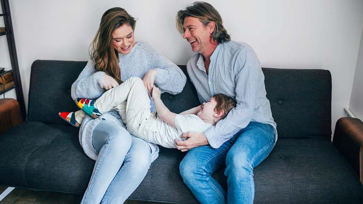 couple on a couch with their son straddling their laps