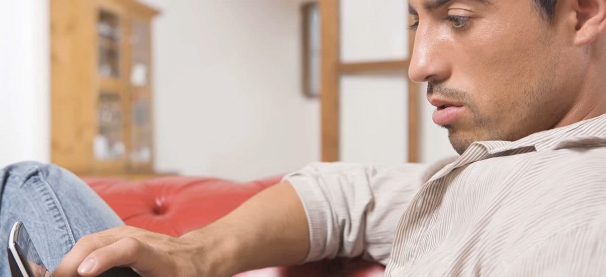 seated man looking at his mobile phone