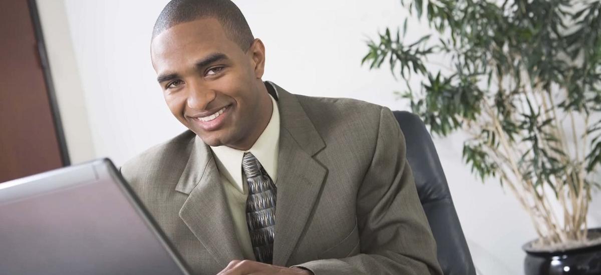 smiling businessman using a laptop computer in an office