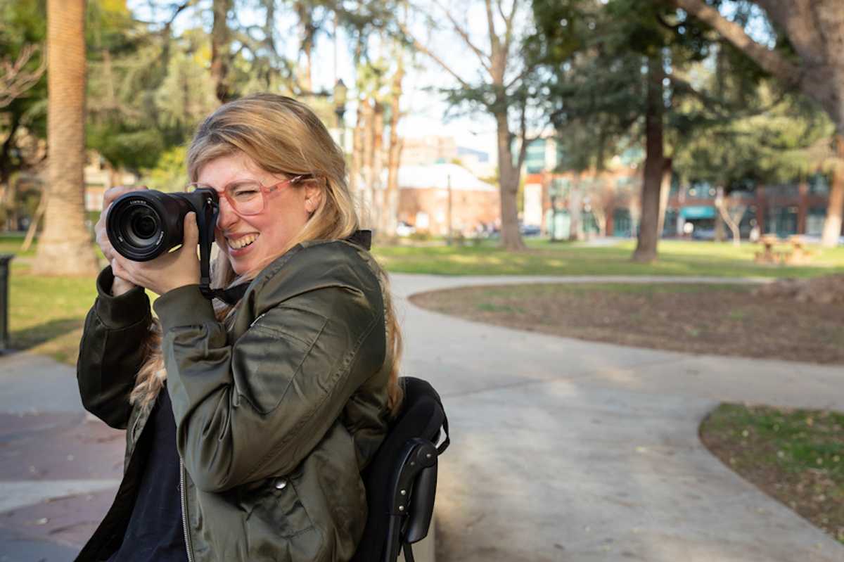 Woman in a wheelchair takes a photo