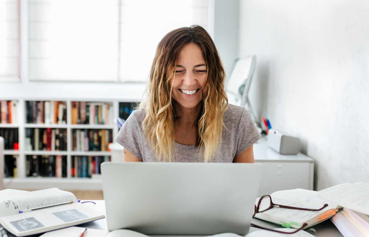 Woman works on laptop computer at home