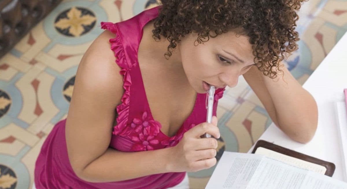 woman holding a pen and reviewing paperwork