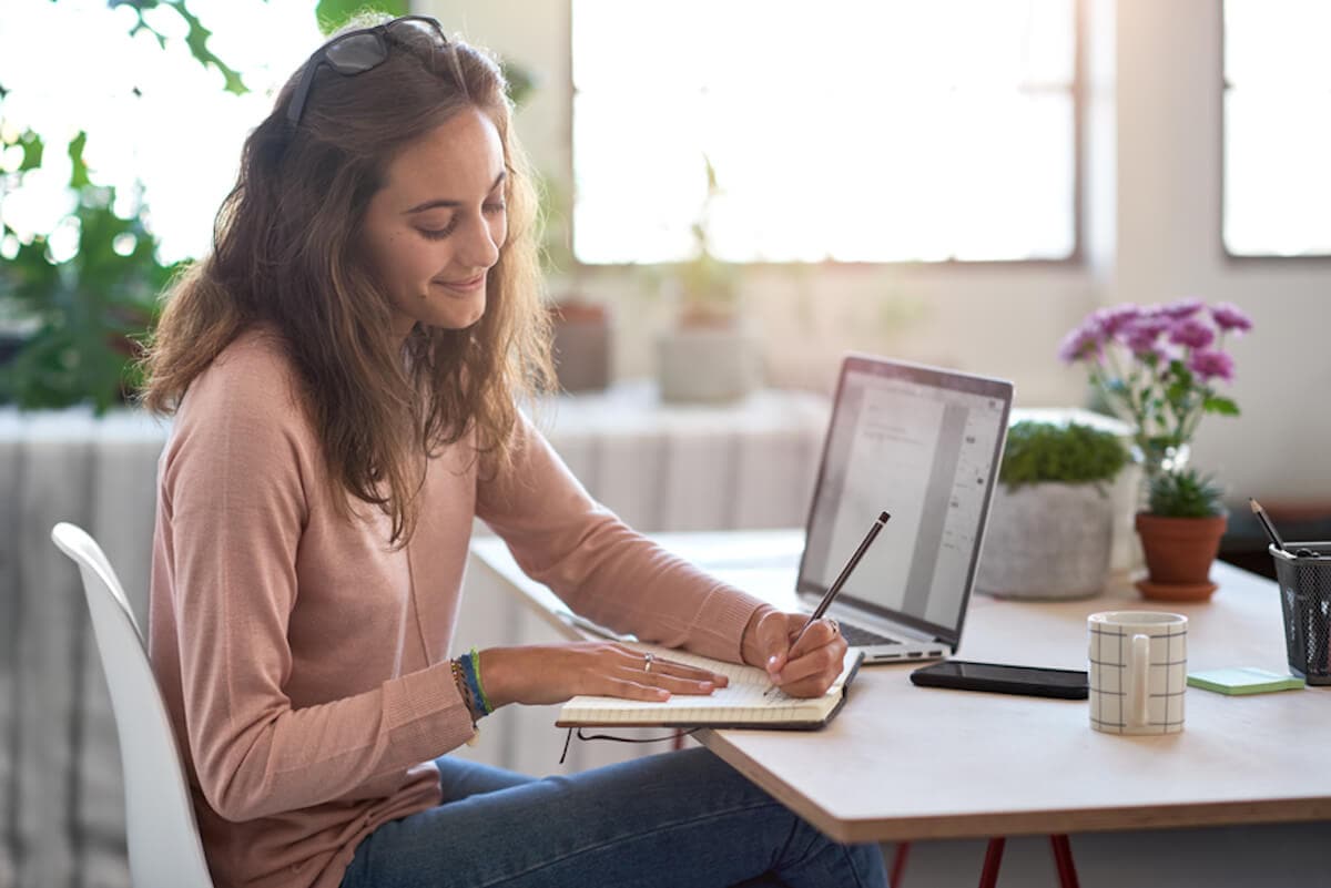 Young businesswoman plans her day in plant-filled office