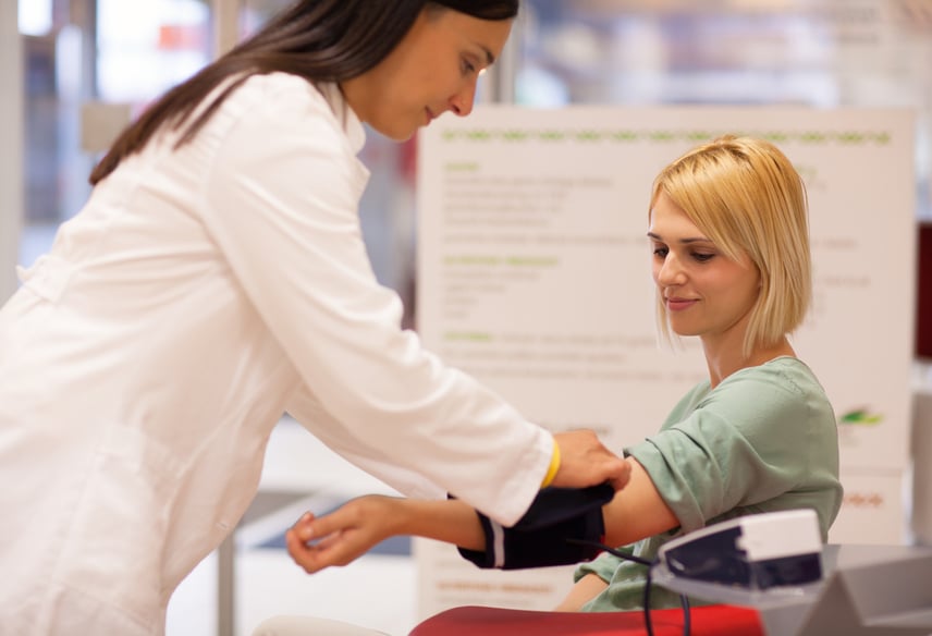 female medical professional taking the blood pressure of a patient