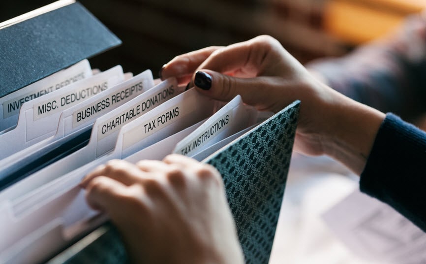 Woman digging through tax folders to find receipts