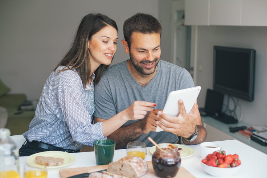 Happy couple having breakfast and looking at their IRA contributions.