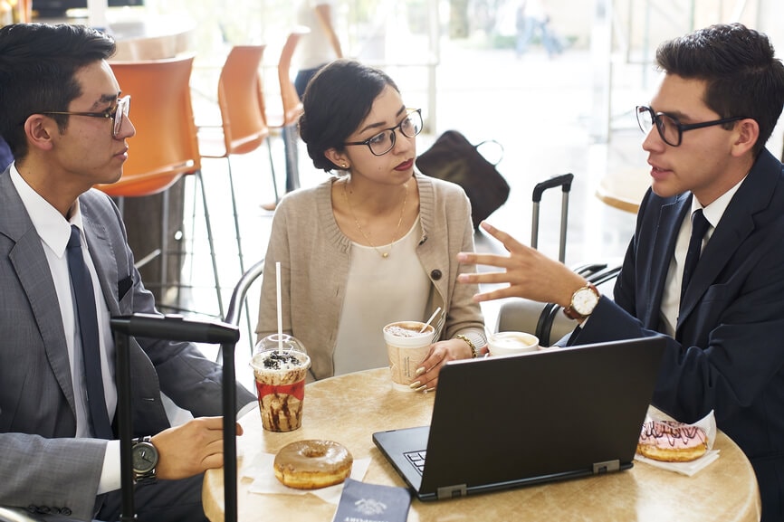 3 young business people discussing investment options at the coffee shop.