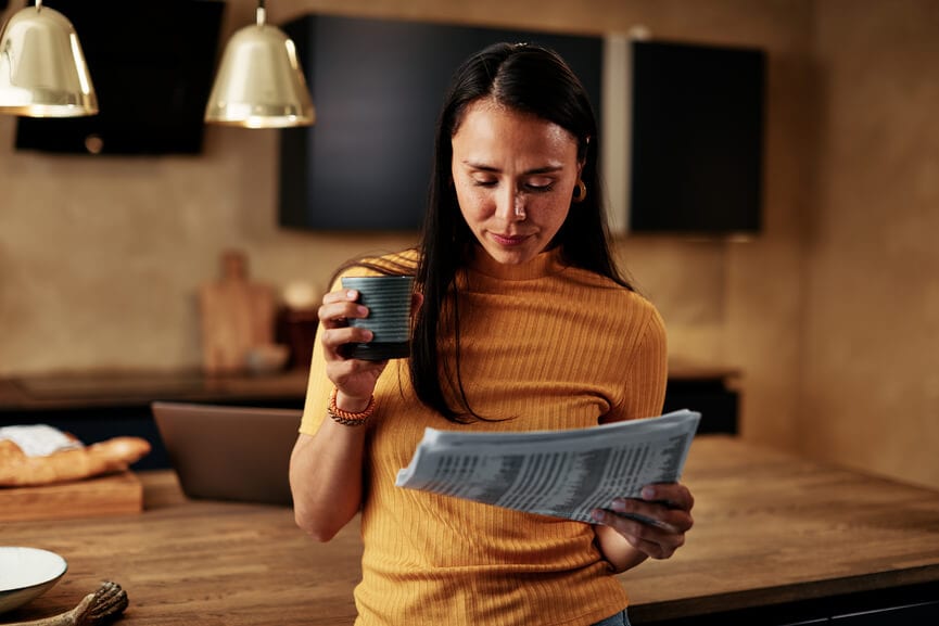 Person reading newspaper in kitchen