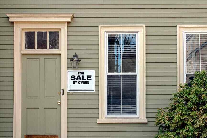 A house with a door and a window with a sign on it.