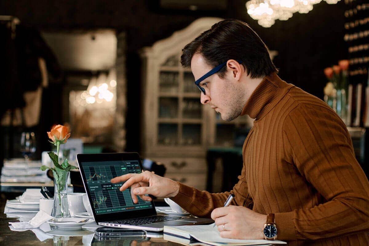 Un hombre mira una computadora que muestra datos del mercado de valores.