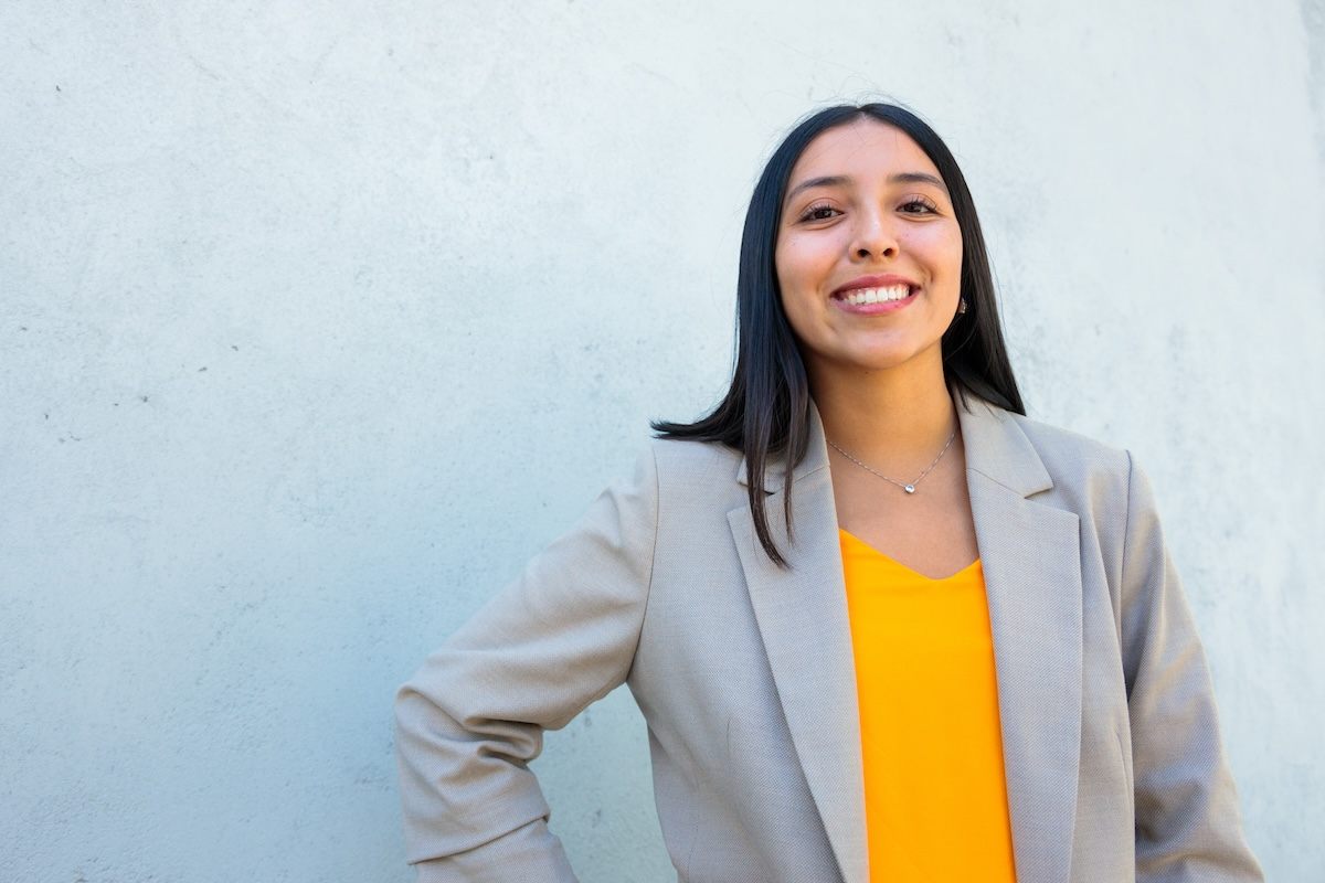 A person wearing a shirt and tie smiling.