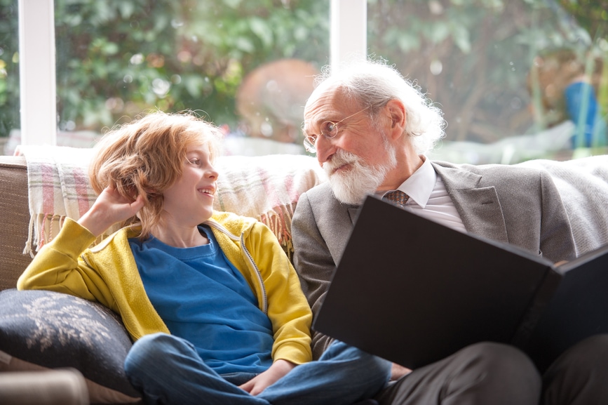 Grandfather and grandson sitting in front of window