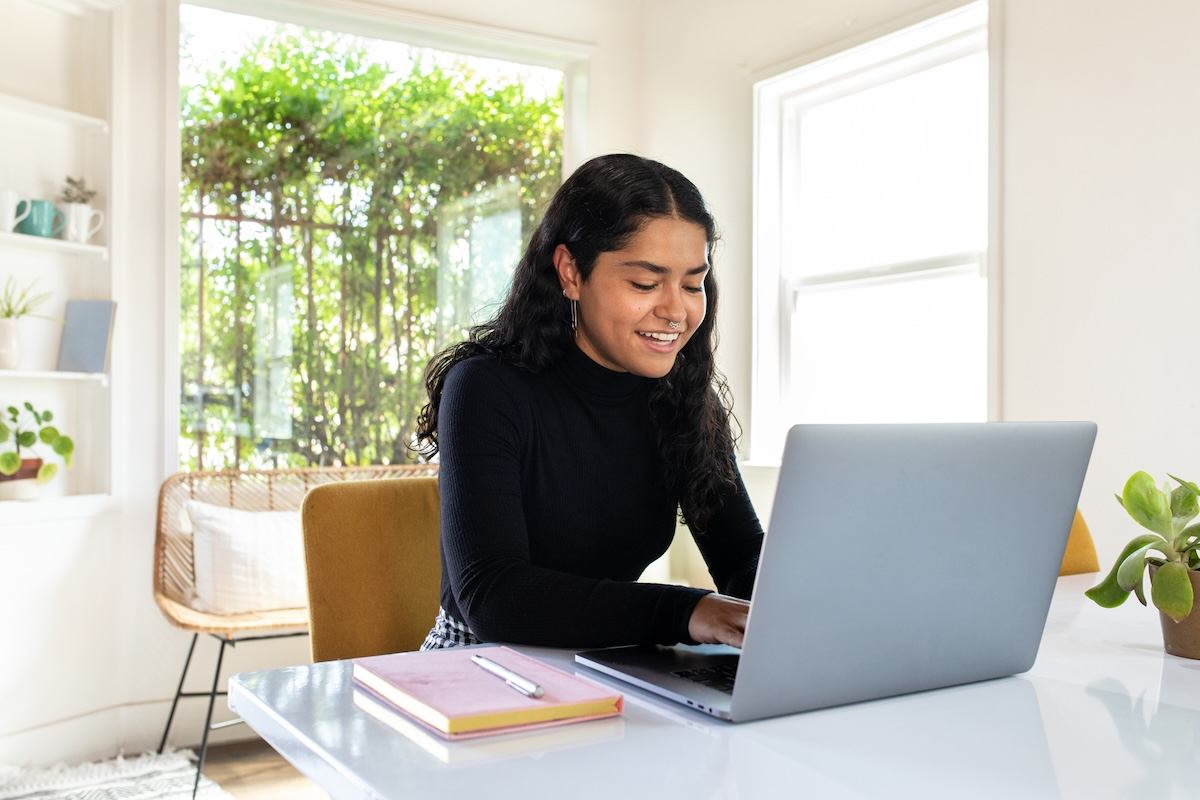A person sitting at a desk with a laptop computer.
