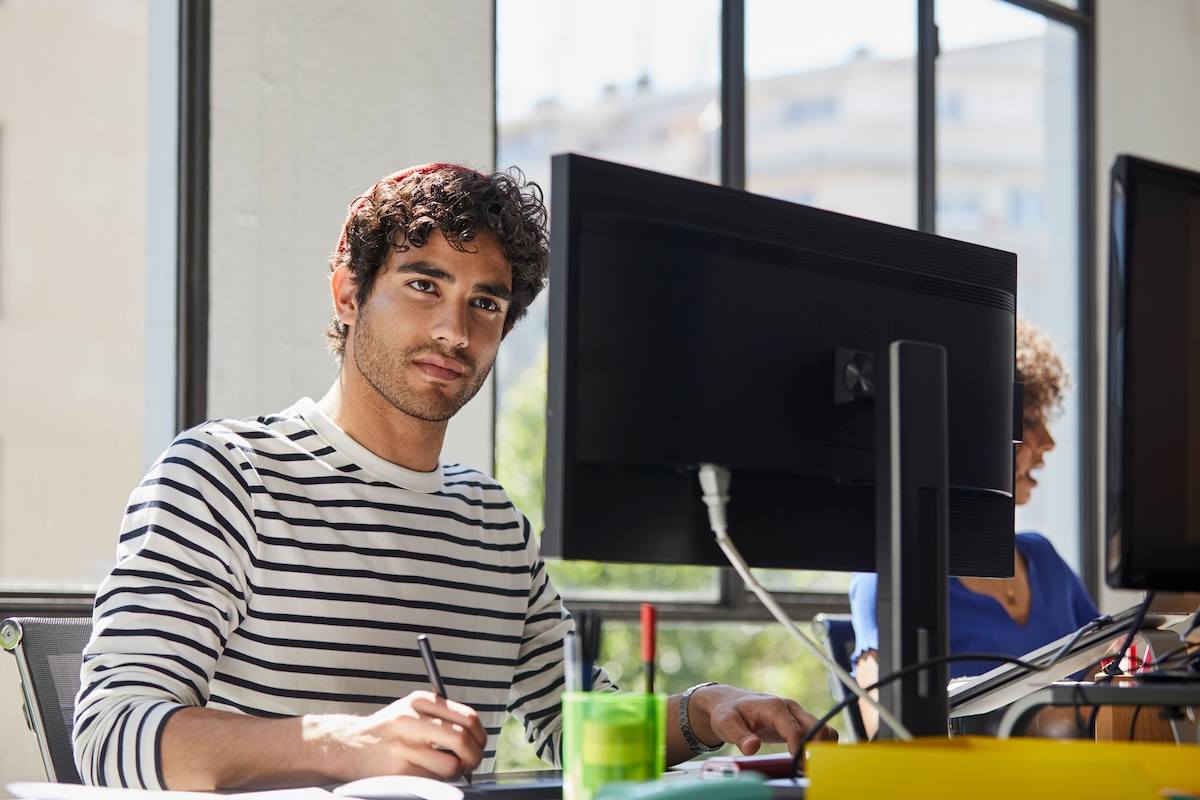 A person is sitting at a table with a laptop.