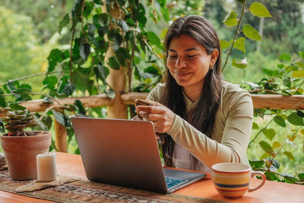 A person sitting at a table using a laptop computer.