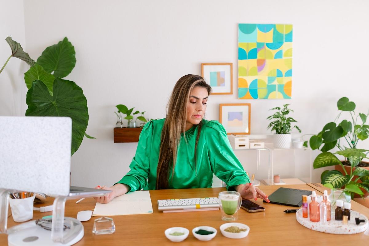 A person sitting at a desk with a laptop and a cup of coffee.