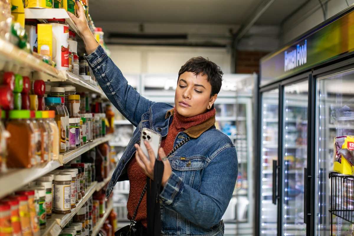 woman looking at phone in grocery store