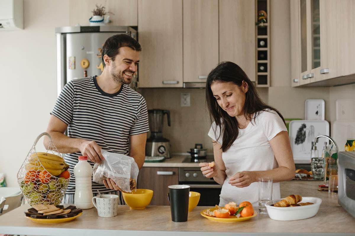 Una joven pareja feliz prepara el desayuno en casa