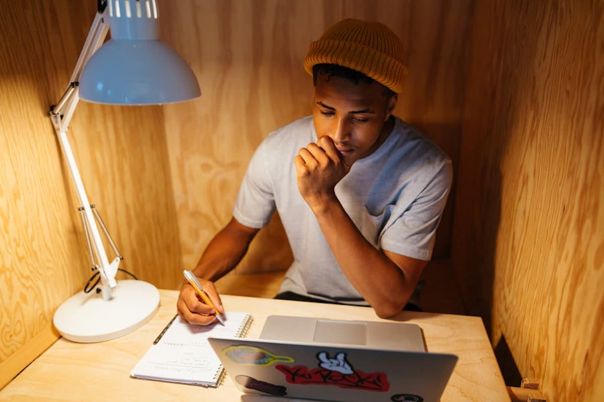 A young professional works at a laptop in a private co-working booth.