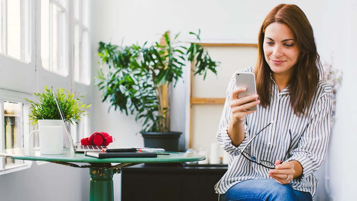 woman looking at her mobile phone and smiling
