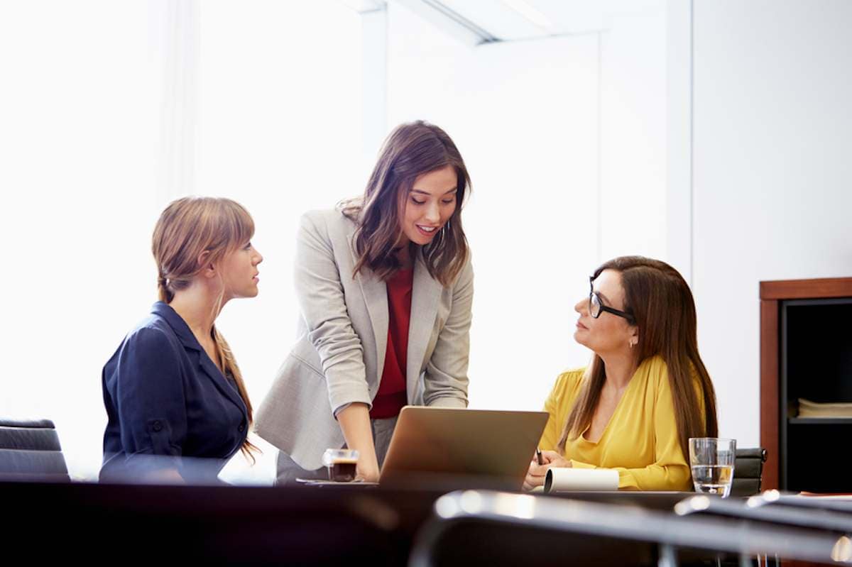 Three female colleagues in office meeting