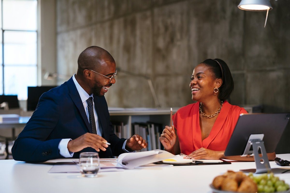 A person and person sitting at a table with a cup of coffee.