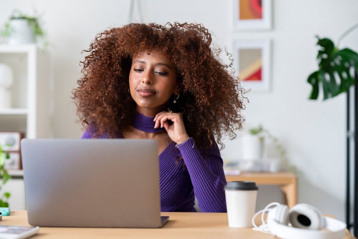 A person sitting at a table with a laptop.