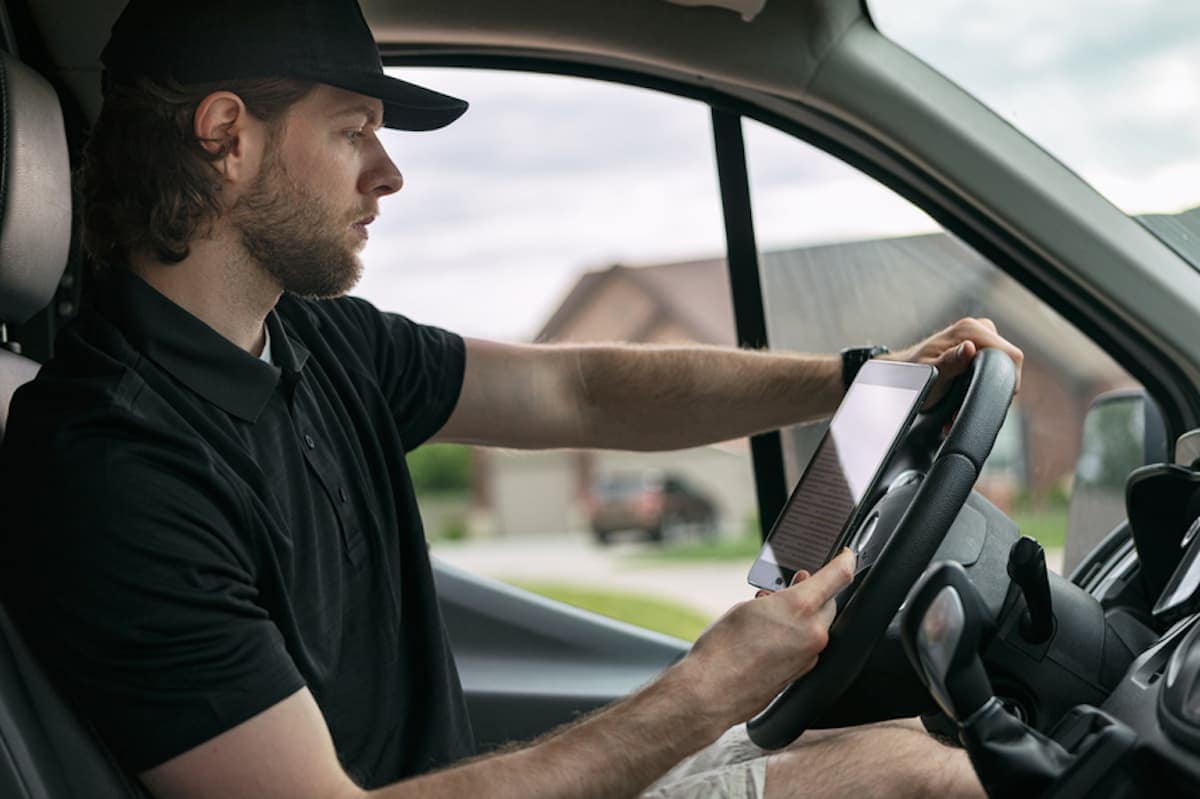 A rideshare driver checks his schedule on his mobile device